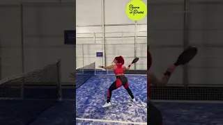 Cute woman doing one arm handstand while playing padel