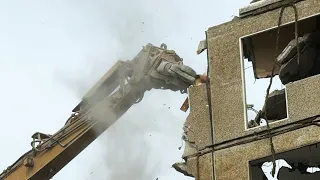 Bagger knabbert sich durch DDR-Plattenbau