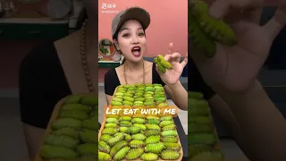 Beautiful Chinese girl eating green worms