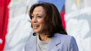 Kamala Harris claps along to a group protesting her