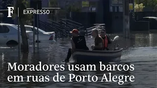 Moradores cruzam de barco ruas alagadas em Porto Alegre