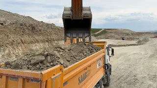 Hitachi excavator loading trucks.