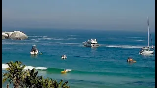 Clifton kayakers playing in waves on a sunny beach day. From Clifton 4th Livestream webcam