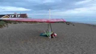 High wind Hangliding take off  lying prone on beach and flying backwards.