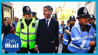 Police escort Jacob Rees-Mogg as swarm of hecklers chant 'Tory scum'