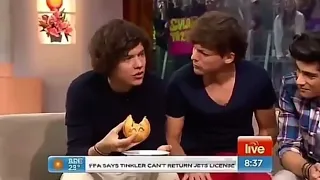 louis and harry sharing food with one another during the australian interview