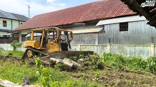 Good job D6R Bulldozer Operator Cleaning Wild Grass in the Yard of a Long Abandoned House