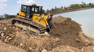 Power Bulldozer Komatsu D60P pushing land into big lake build long road