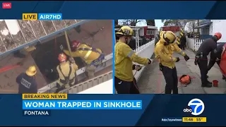 FULL RESCUE: Woman trapped in 25-foot sinkhole in Fontana; firefighters on scene