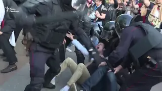 Полицейские избивают лежащих на земле людей. Протесты в Москве