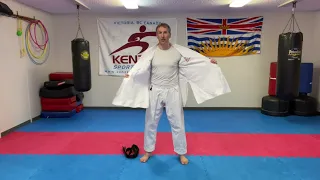 Wearing a Kenzen karate uniform and tying a karate belt