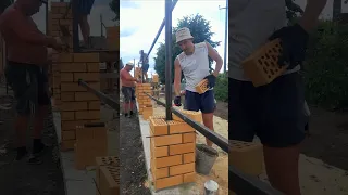 Каменщики кладут кирпичные столбы для забора. Fence construction
