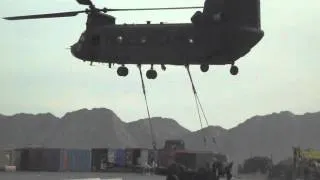 Chinook lifting off with Howitzer sling loaded