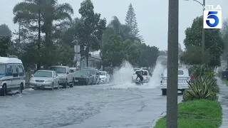 Locals surf on flooded street in Ventura, California