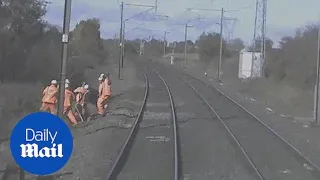 Railway workers run for their lives as train speeds towards them