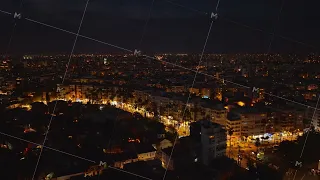 Night cityscape. Aerial descending footage of large city, illuminated streets and buildings in urban