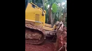 Komatsu D51EX bulldozer repairs road in banana plantation