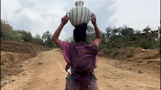 Acarrea agua del pozo, con su bebé en la espalda | doña Filomena