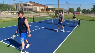 A pickleball paddle with a pair of dentures snapping at the ball.