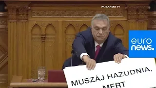 Hungarian opposition MP holds 'lies' sign during Orban's parliament speech