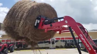 Mahindra 2638 HST lifting a 5 x 6 round bale