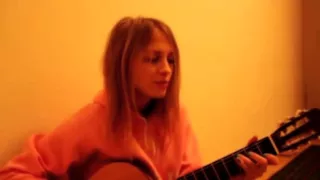 Девушка очень красиво играет на гитаре и поет новую песню