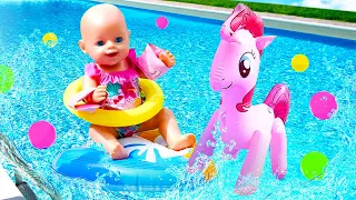 Baby Annabell doll goes to the beach. Baby doll swimming in a pool with swimsuit & water toys.