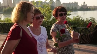 Парень раздает розы случайным прохожим на Оболонской набережной