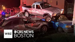 Driver flees crash after pickup truck lands on top of two parked cars in Brockton