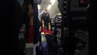 Three Police Officers Drag a Large Woman Off a Delta Air Lines Jet in Detroit Michigan DTW
