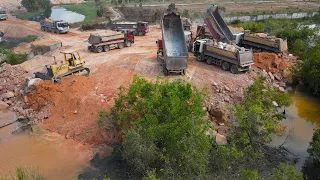 Nice Team Working Operator Bulldozer Spreading Stone and many Dump Truck Unloading Stone Filling Up