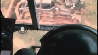 A CH-54 Skycrane loads and delivers a bulldozer on ground in Vietnam HD Stock Footage