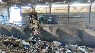 Garbage trucks dumping in transfer station pit.