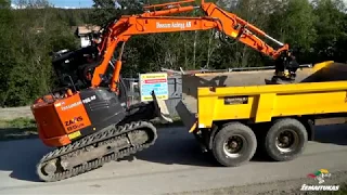 Excavator climbing to MUSTANG dump trailer (no ramps). Widest dumper range in the market