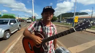 Parado no sinal homem toca violão para ganhar um trocado para ganhar a vida...