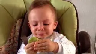 Bebé comiendo limón por primera vez.