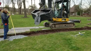 Concrete bucket on excavator placing stone