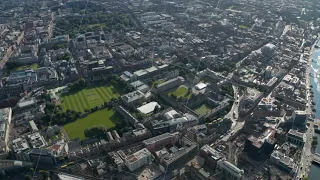 Fly above city. Aerial footage of high variety town development. Trinity College complex. Dublin