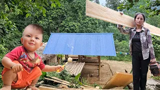 A poor woman works hard with large pieces of wood to build her dream house