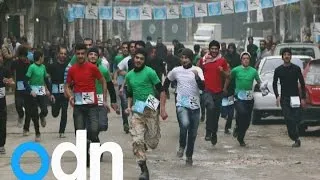 Runners race through rubble in war-torn city of Aleppo in Syria