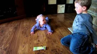 Big brother helping baby sister learn to crawl.MOV