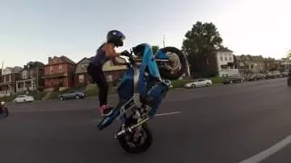 Девушка выполняет сумасшедшие трюки на мотоцикле. She performs crazy stunts on a motorcycle.