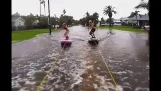 Extreme couple surf down STREETS flooded during Hurricane Hermine