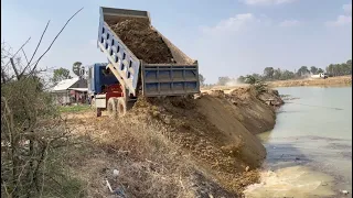 New project Dump trucks pouring into the river to make a path across this deep river