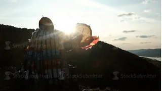 Slow motion of the silhouette of a shaman with a tambourine at sunset.