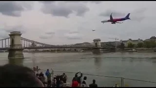 Wizz Air plane flies across the Chain Bridge in Budapest