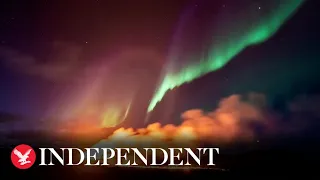 Northern Lights shine over Iceland's erupting volcano in stunning footage