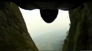 Wingsuiter dives through narrow valley