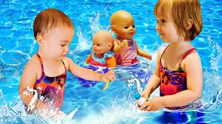 Jeux à la piscine. Bianca et Marta nagent et jouent avec poupons Baby Born.