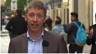 Tall Woman towers over male reporter BBC News